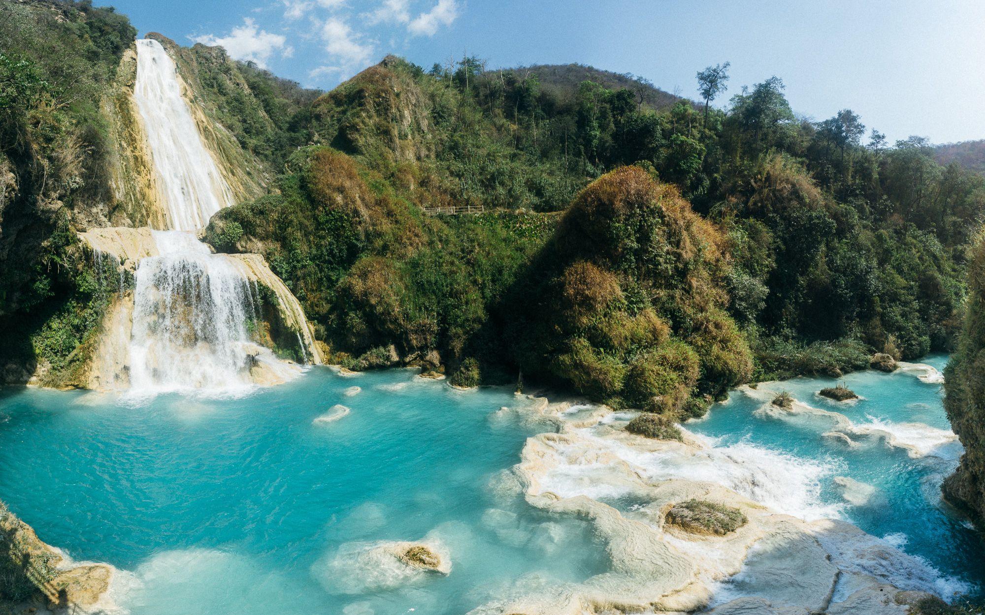 A tall waterfall with beautiful blue water lagoons